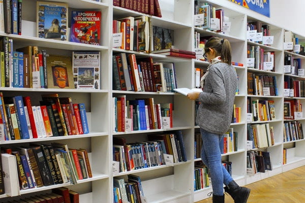 Person in a library looking at books