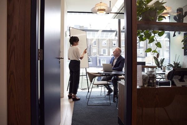 Two people talking in an office setting.